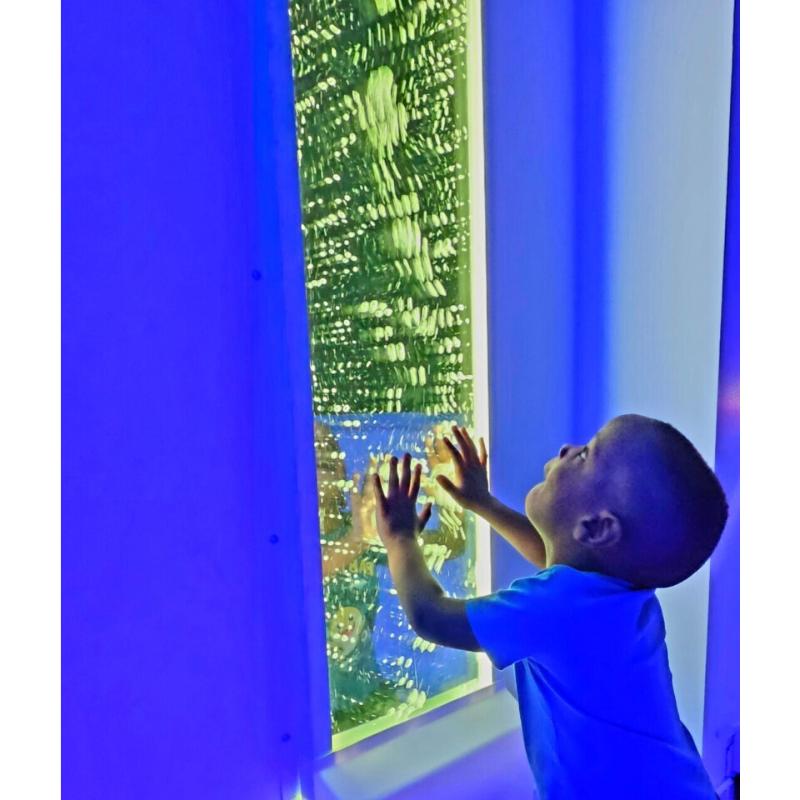 child in front of TFH Bubble Wall 60" with green lighting
