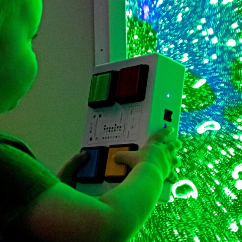 child holing a controller for a TFH Bubble Wall 60" with blue and green lighting