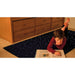 Child reading a book on the TFH Fiber Optic Starfield Carpet
