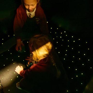 children playing on TFH Fiber Optic Starfield Carpet on dark sensory room