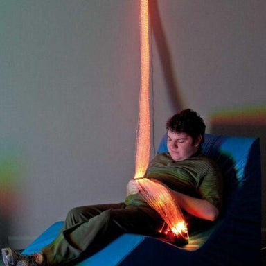 Person sitting in chair with TFH Fiber Optic Wall Sconce with Tails in their hands