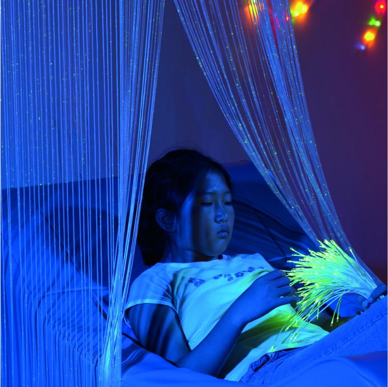 Girl lying under TFH Fiber Optic Waterfall in dark sensory room