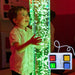 Boy playing with TFH Interactive Bubble Tubes with green lights and control  detail