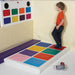 Child standing on colorful TFH Musical Squares and looking at colorful squares on the wall