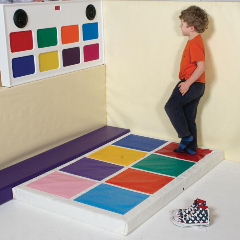 Child standing on colorful TFH Musical Squares and looking at colorful squares on the wall