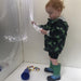 Child playing with the Fiber Optic Spray inside the TFH Portable Sensory Den 