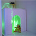 Toy figure in front of a TFH Portable Sensory Den with green lighting