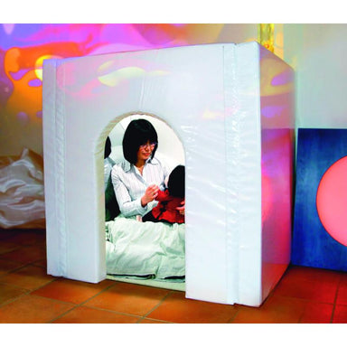 Woman with a doll sitting inside a TFH Portable Sensory Den with colorful projections on the wall