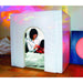 Woman with a doll sitting inside a TFH Portable Sensory Den with colorful projections on the wall