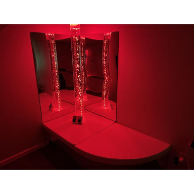 TFH Quadrant Podium Bench in a room with mirrors on the wall and a bubble tube with red lighting