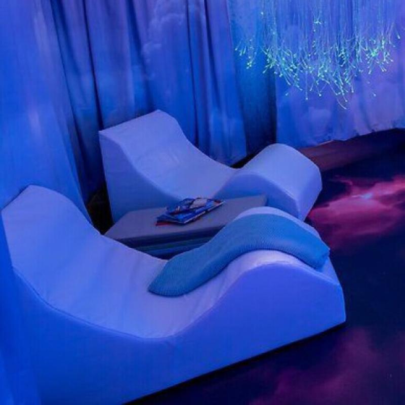 Two white TFH Relaxer Chairs in a sark sensory room setup