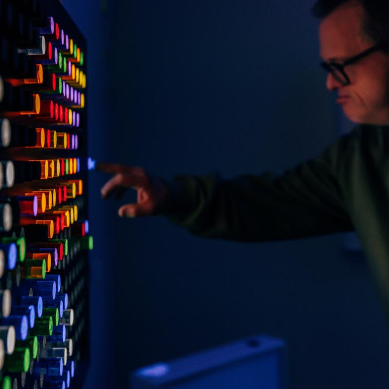 Person interacting with the TFH Rod Wall Light Panel in dark sensory room