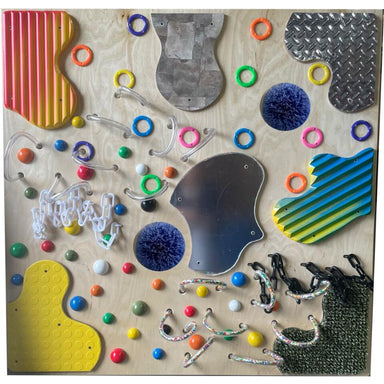Colorful TFH Textured Tactile Wall with various shapes and objects on a wooden surface
