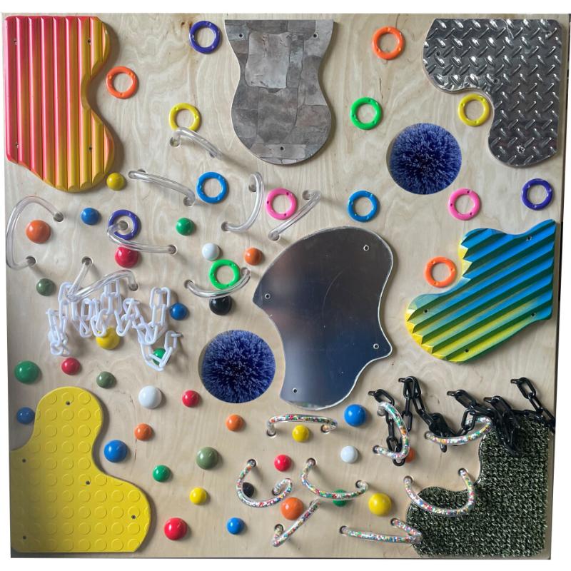 Colorful TFH Textured Tactile Wall with various shapes and objects on a wooden surface