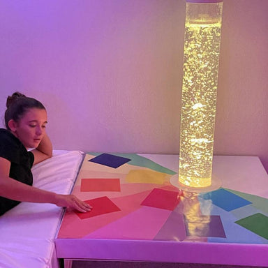 Girl in a room with a TFH Touch-A-Color Podium and bubble tube with yellow light