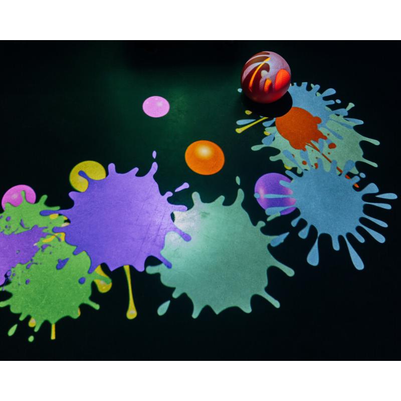 Colorful splashes on a black background with a small ball-like object.