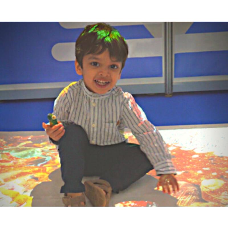 child playing with a projection of the TFH Vecta Budii Projector